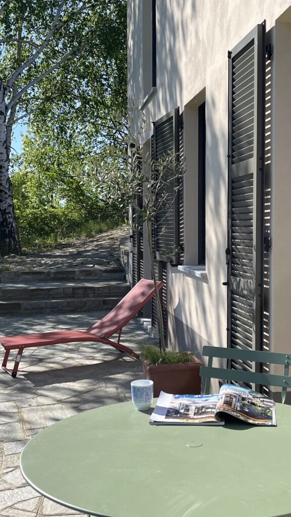 Terras met ligstoelen en tafeltje met stoelen achterkant van ons vakantiehuis.