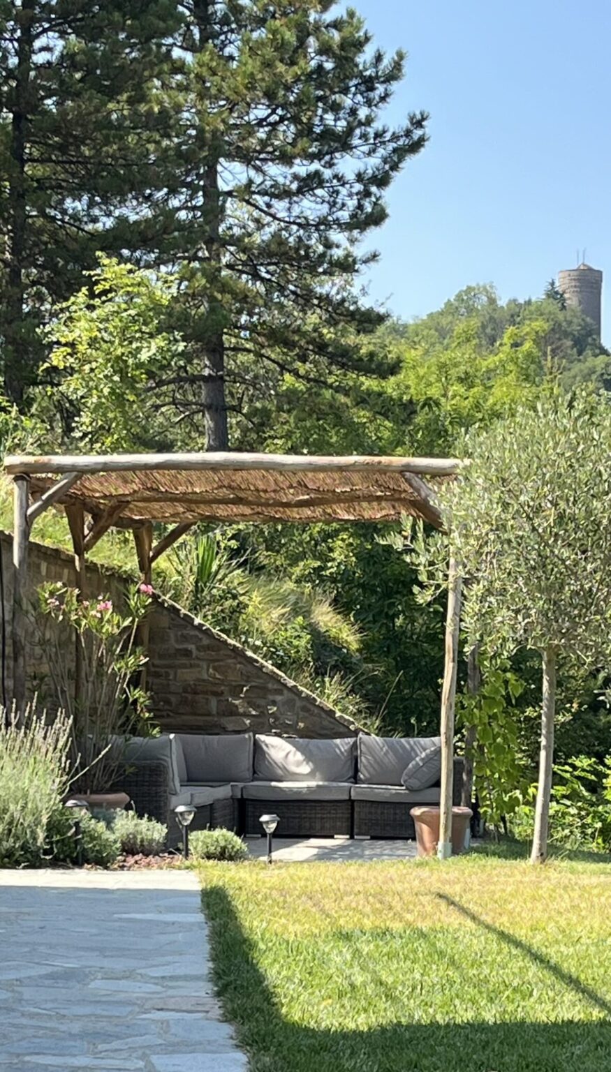 Gezellig terras met zithoek en comfortabele tuinbeubelen. In de verte Roccaverano.